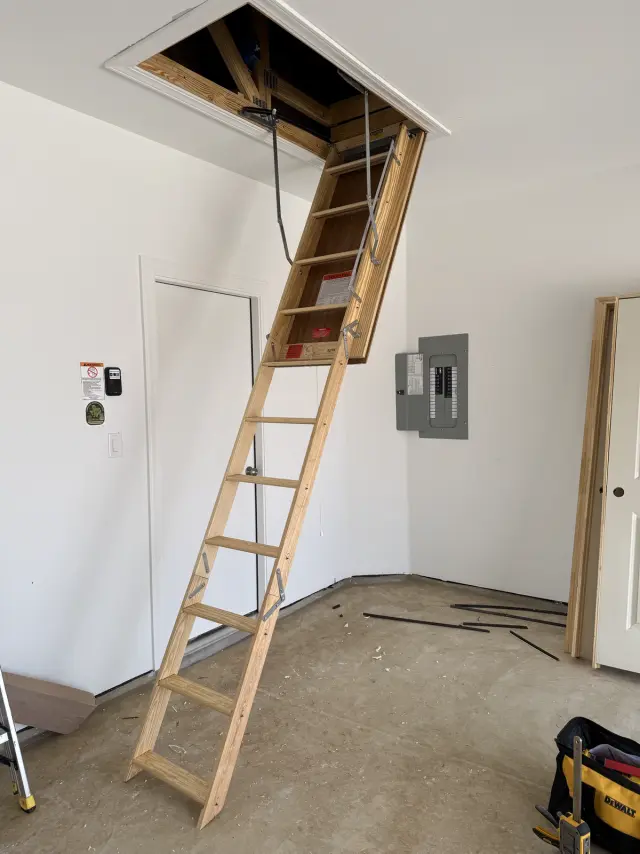 Folding attic ladder installed in a garage ceiling