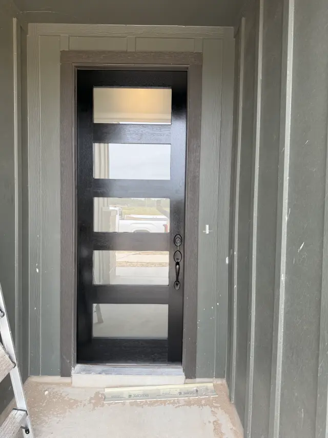 Dark modern entry door with five horizontal frosted glass panels and black hardware