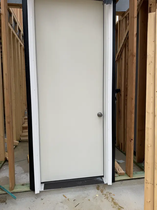 Pre-hung exterior door installed plumb in a freshly framed wall