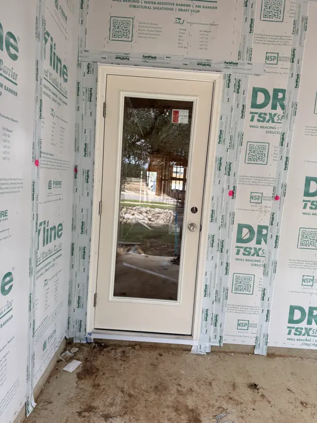 White full-glass entry door installed on a new home under construction