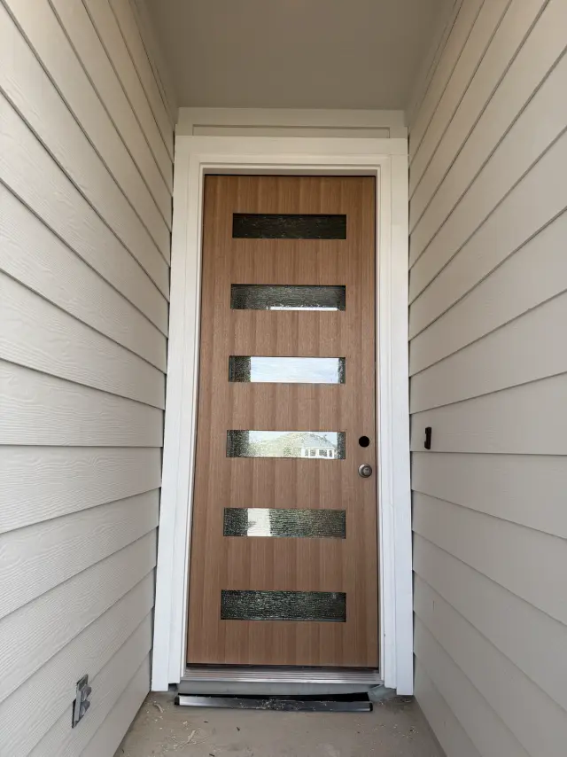 Modern wood-grain entry door with six horizontal glass panels, installed with white trim