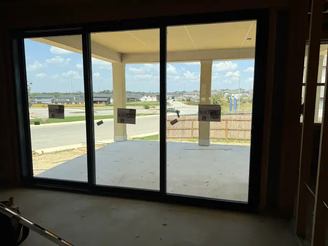 Inside view of a black three-panel sliding glass door opening onto a covered patio