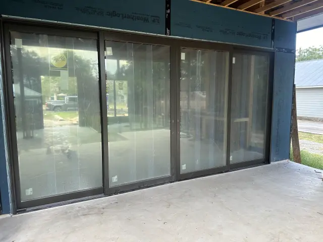 Large black-framed multi-panel sliding glass wall installed on a home addition