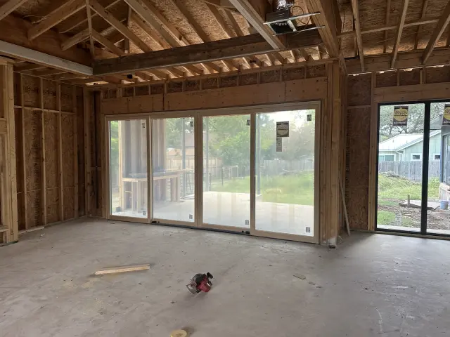 Four-panel multi-slide glass door installed in a framed great room during construction